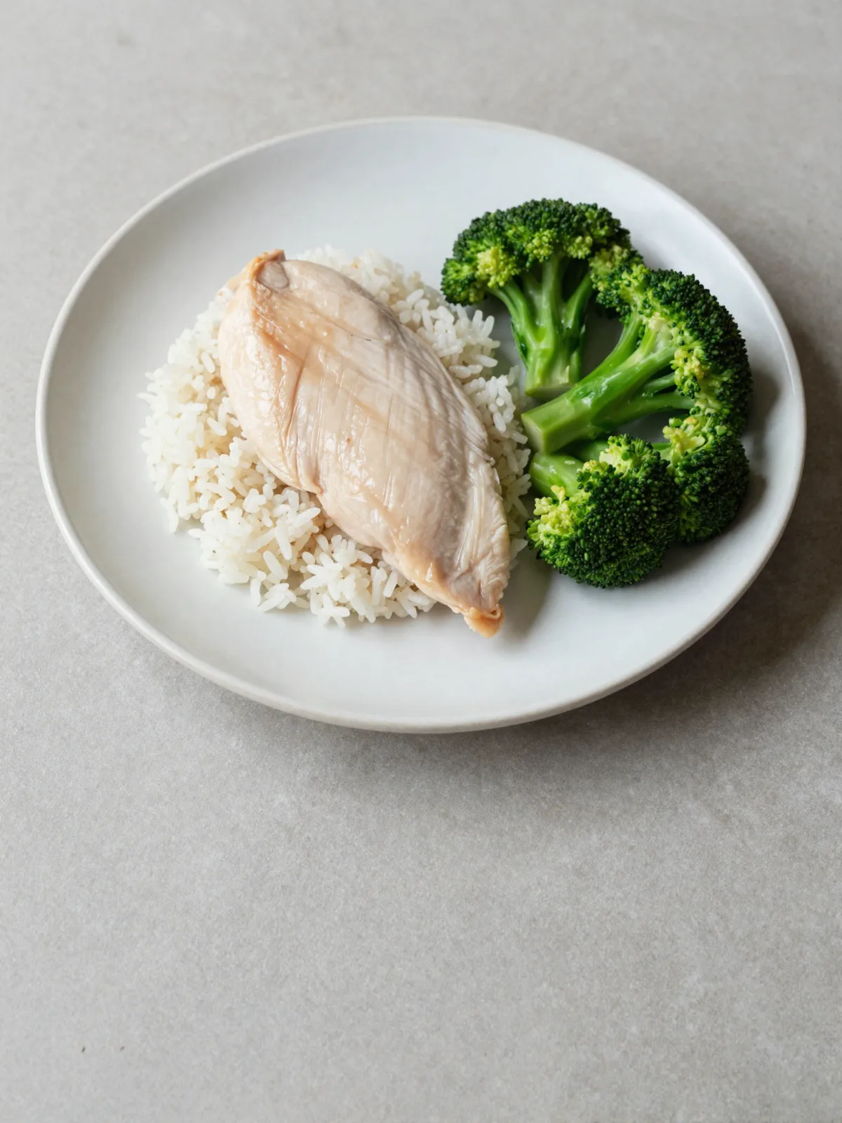 A plate of plain boiled chicken, white rice and broccoli - clean, and completely bland